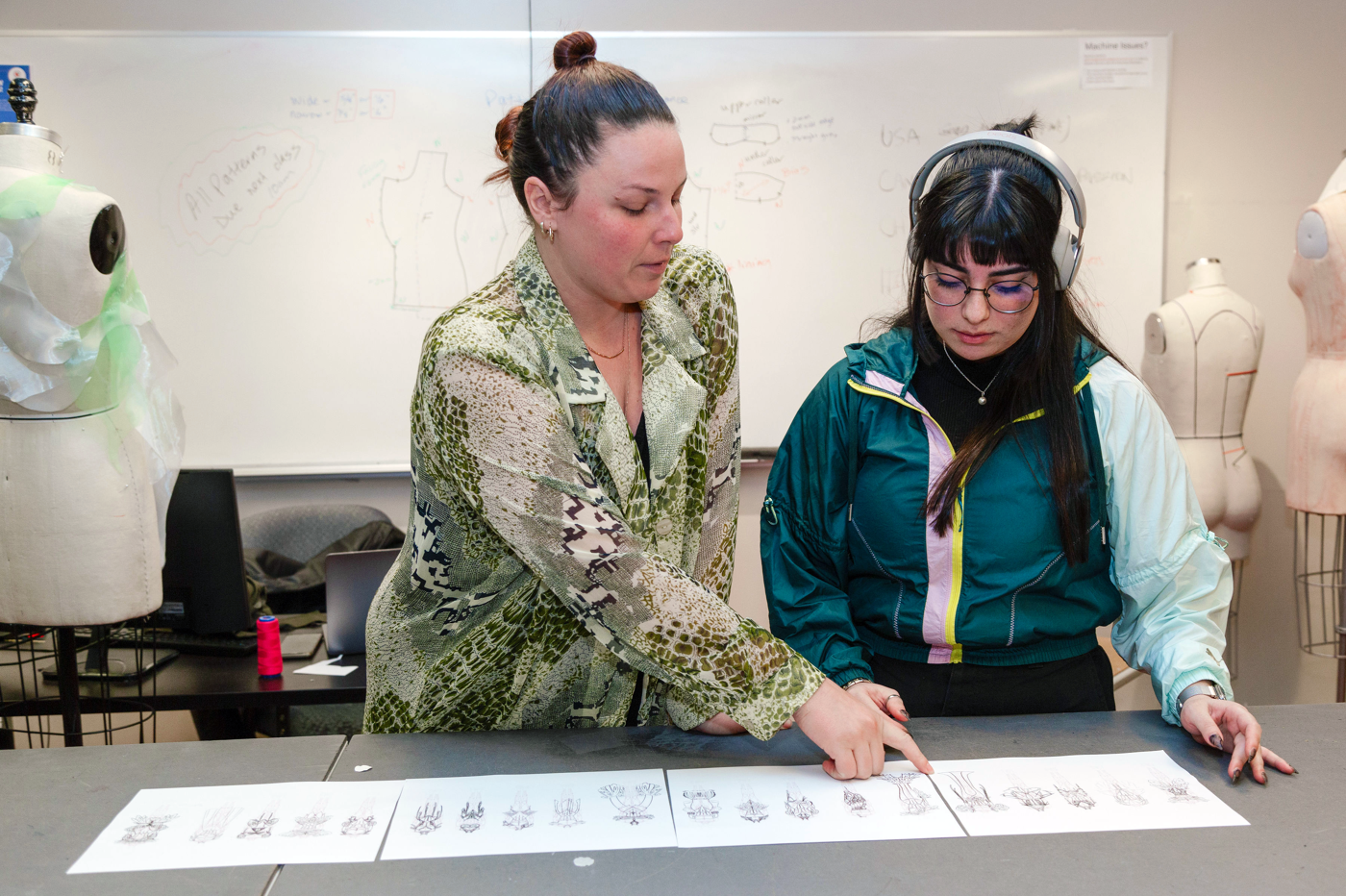 In the image, a woman is showing a man a long sheet of paper with handprints on it, possibly discussing a project or an artistic piece.