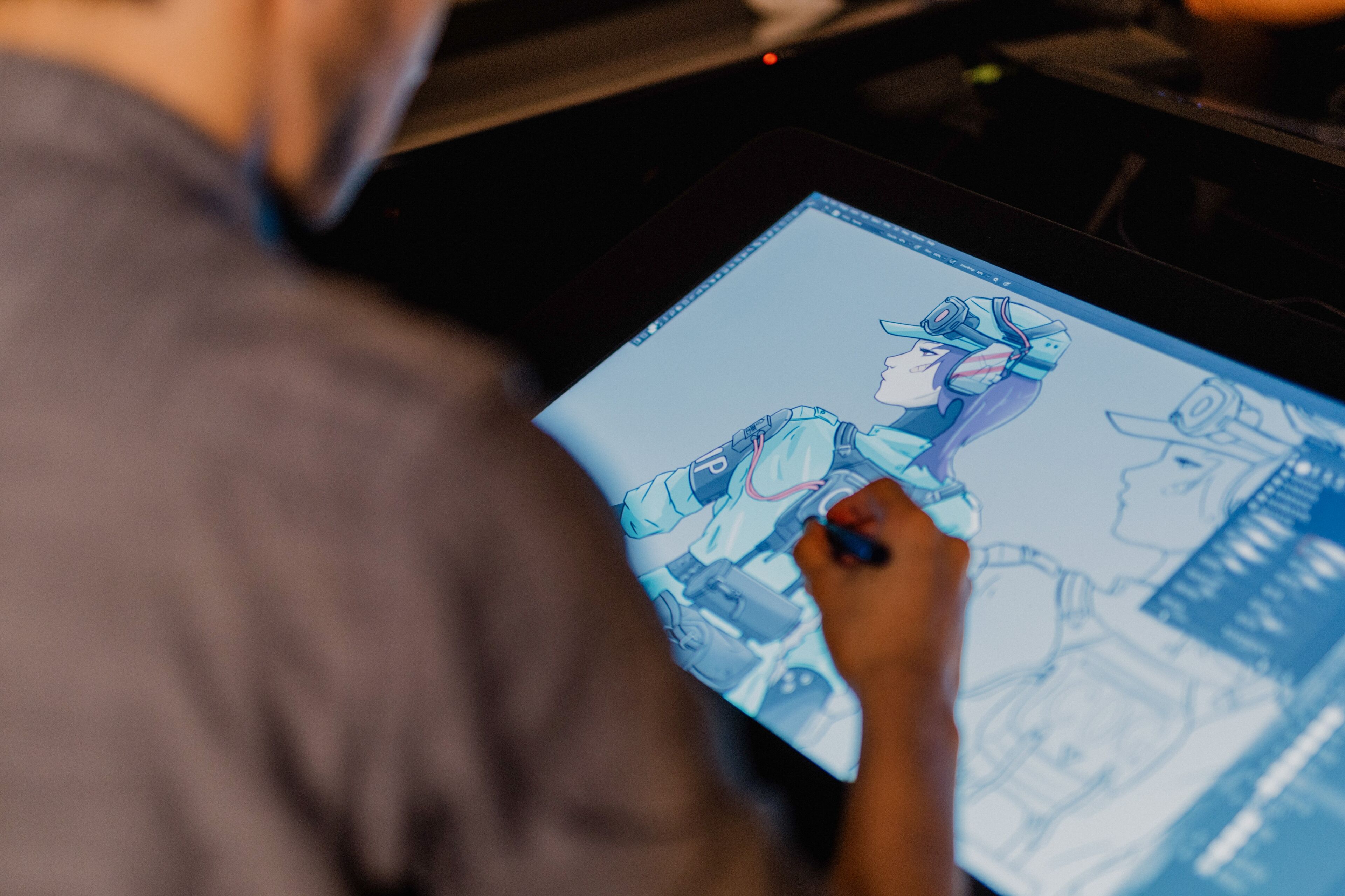 Over-the-shoulder view of an artist refining a futuristic character design on a graphic tablet.