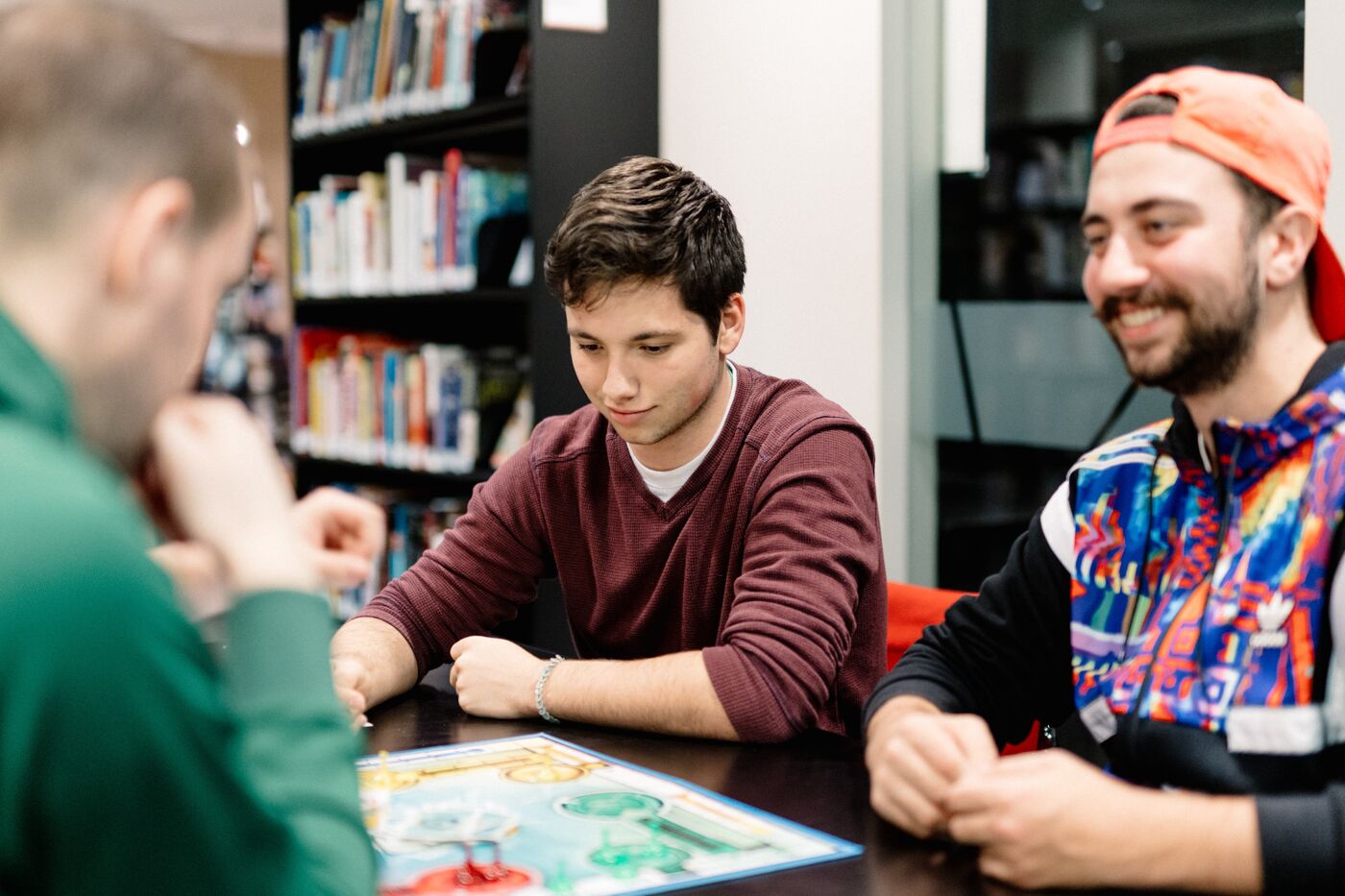 Friends gathered around a board game, enjoying a strategic challenge and each other's company.