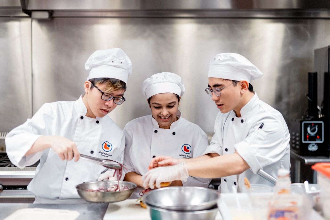 Aspiring chefs work together to master a new recipe in a professional kitchen.