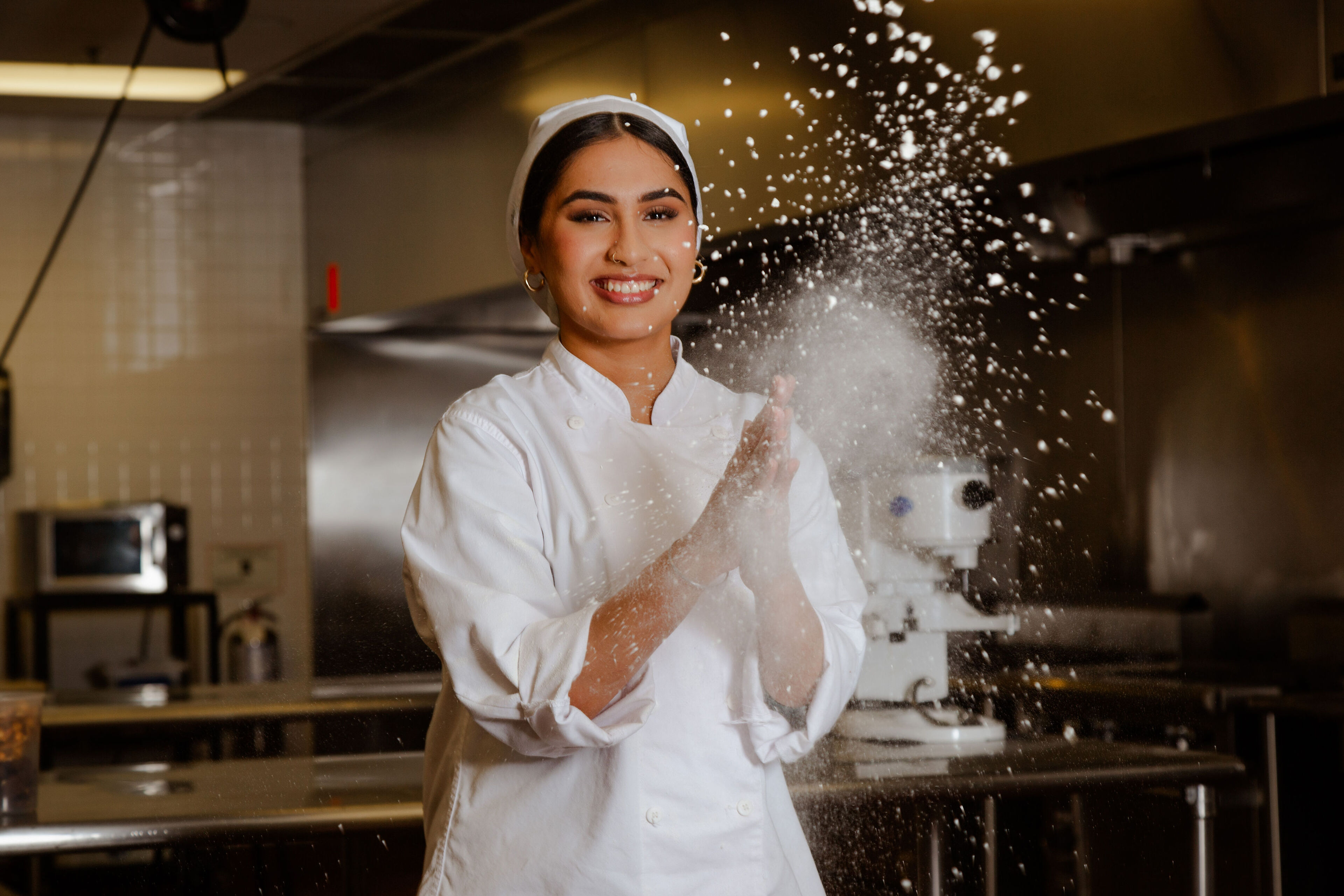 A cheerful baker in white uniform clapping hands with flour, creating a dynamic scene.