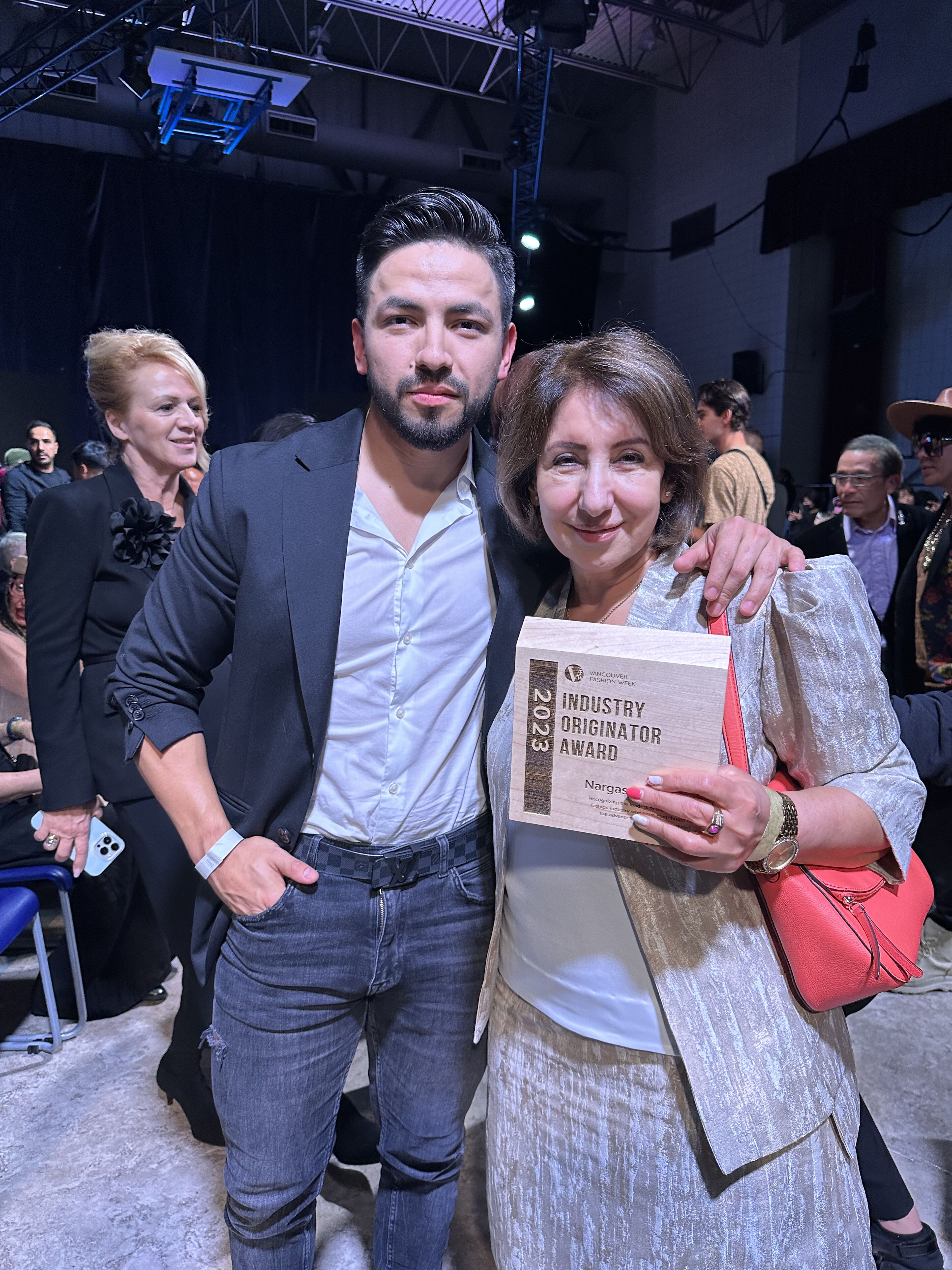 A man and a woman posing with an 'Industry Originator Award' at an event.